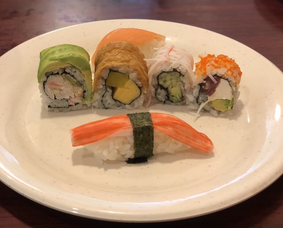 Buffet line with hibachi grill and mixed dishes.